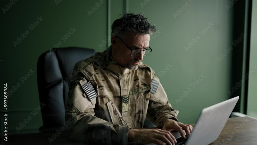 Soldier with glasses working with laptop in home. Everyday life of a military man in reserve. Work and communication online