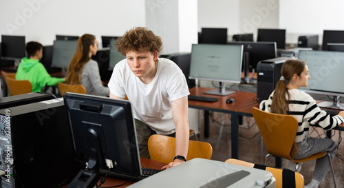 Modern teenage student learning basics of programming in group course in computer college