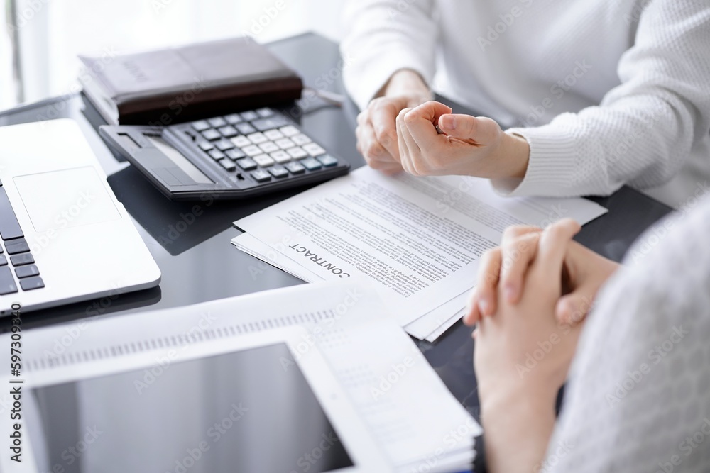 Woman accountant using a calculator and laptop computer while counting taxes for a client. Business audit concepts Woman accountant using a calculator and laptop computer while counting taxes for a client. Business audit concepts