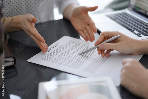 Fototapeta Naklejka Na Ścianę i Meble -  Businesswoman lawyer pointing into contract special points admitting something for colleague or client at meeting. Business people teamwork and partnership