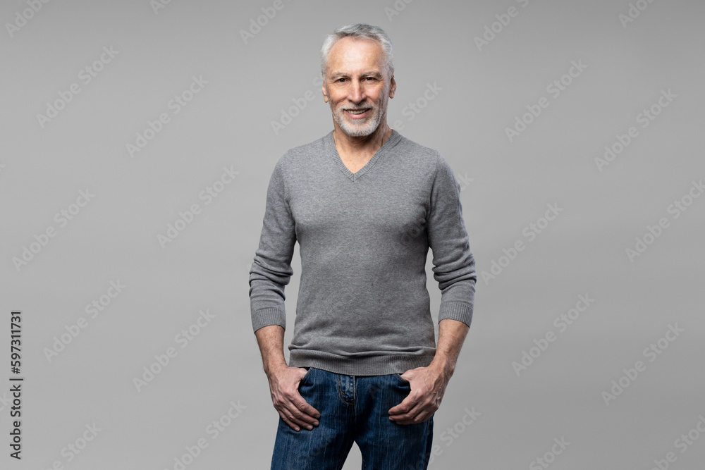 Caucasian confident senior man in casual clothes, smiles looking at camera, isolated gray background Caucasian confident senior man in casual clothes, smiles looking at camera, isolated gray background