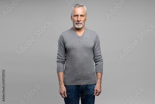 Obraz na plátně Confident elderly gray-haired bearded man 60s years old, looking at camera, isol