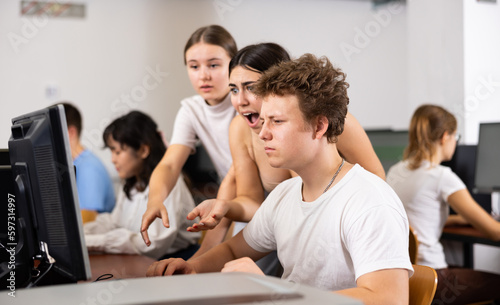 Teenage boys and girls using computers in IT room