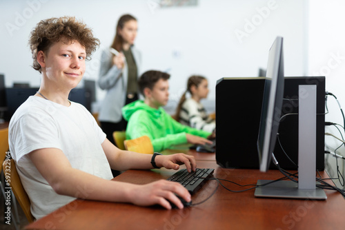 Teenager boy using computer during computer sciene lesson in school.