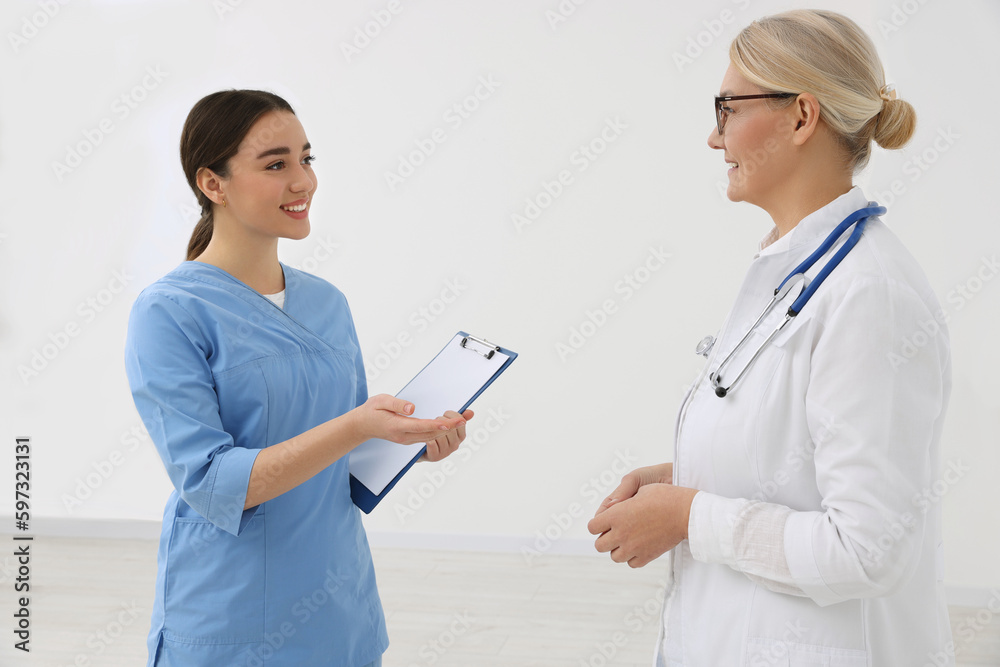 Medical doctors in uniforms having discussion indoors Medical doctors in uniforms having discussion indoors
