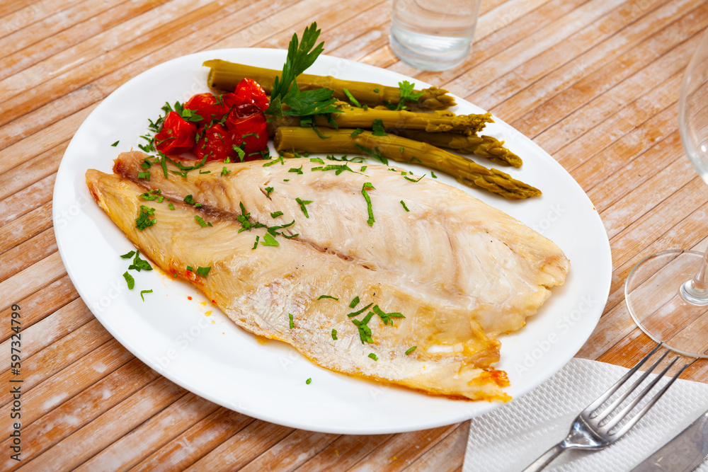 Roasted perch fish fillet served with pickled asparagus and tomatoes