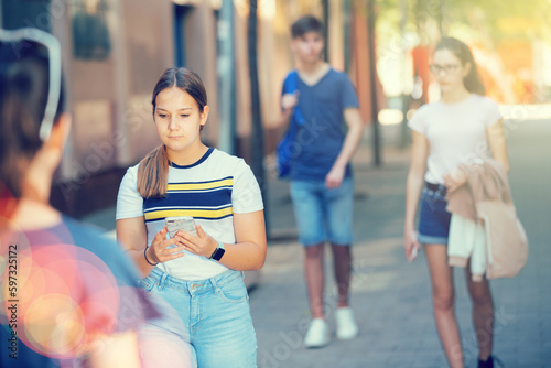 Positive young teen girl walks down the street