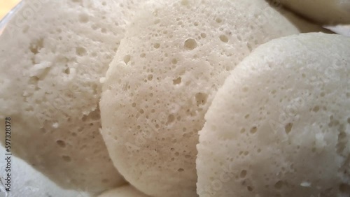 Steamed rice cake, idali, iddali or idli popular traditional vegetarian dish for breakfast and dinner in south Indian states Karnataka, Tamil Nadu and Kerala. Closeup macro side view. photo