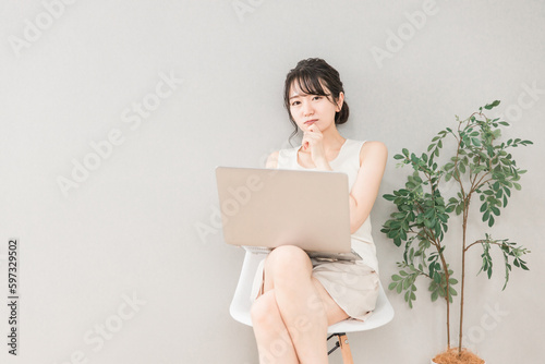 家でパソコンを使って悩む・困る女性 