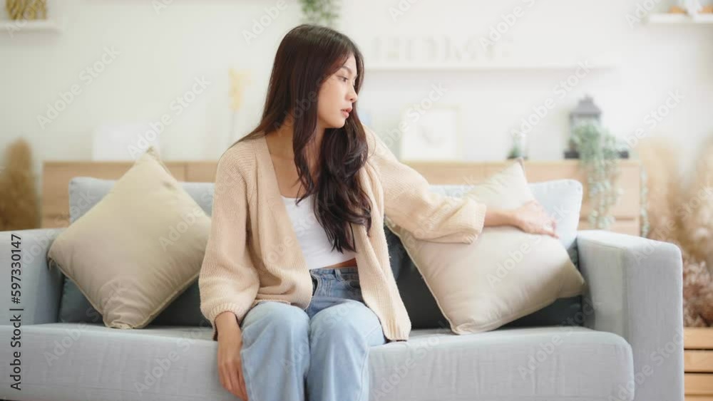 Asian woman resting at home on couch, feeling exhausted after work, lacking energy, or overworked, too tired, and lacking motivation Asian woman resting at home on couch, feeling exhausted after work, lacking energy, or overworked, too tired, and lacking motivation