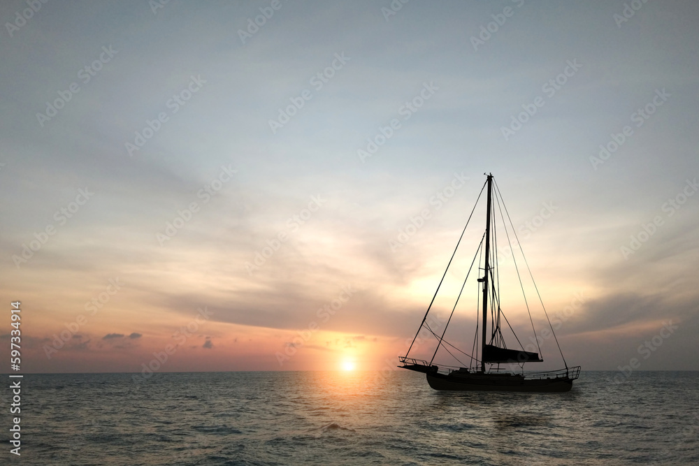 Silhouette of a sailboat on the sea at morning sunrise