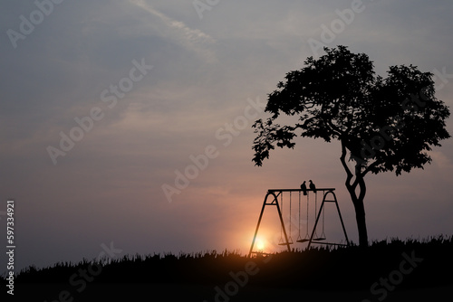 The silhouette of a couple birds perched on a swing under a big tree in the morning atmosphere.