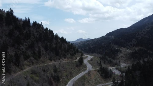 Reveal aerial shot of a lake. Flying in the mountains over a country road | 4K photo