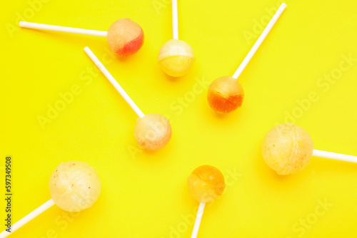 Tasty lollipops on yellow background