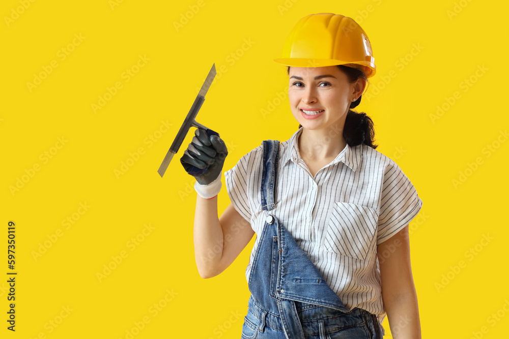 Female decorator with trowel on yellow background