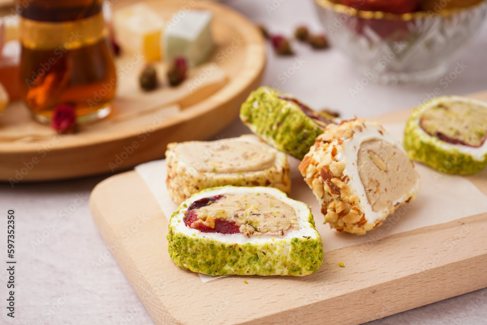 Wooden board with tasty Turkish Delight on light background, closeup Wooden board with tasty Turkish Delight on light background, closeup