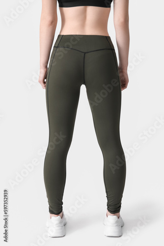 Sporty young woman in leggings on white background, back view