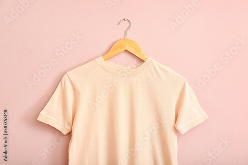 Stylish t-shirt hanging on pink wall
