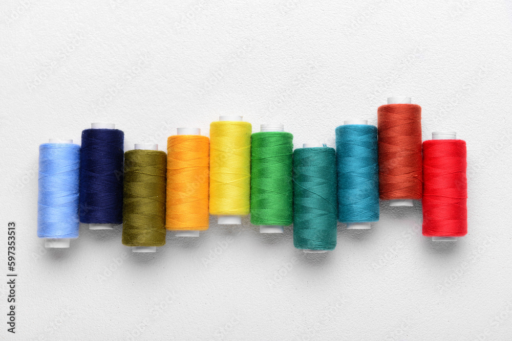 Set of colorful sewing threads on light background Set of colorful sewing threads on light background