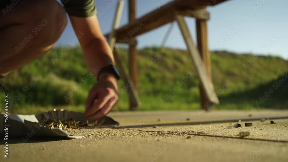 Low angle view: People sweep up, collect used hand gun shell casings