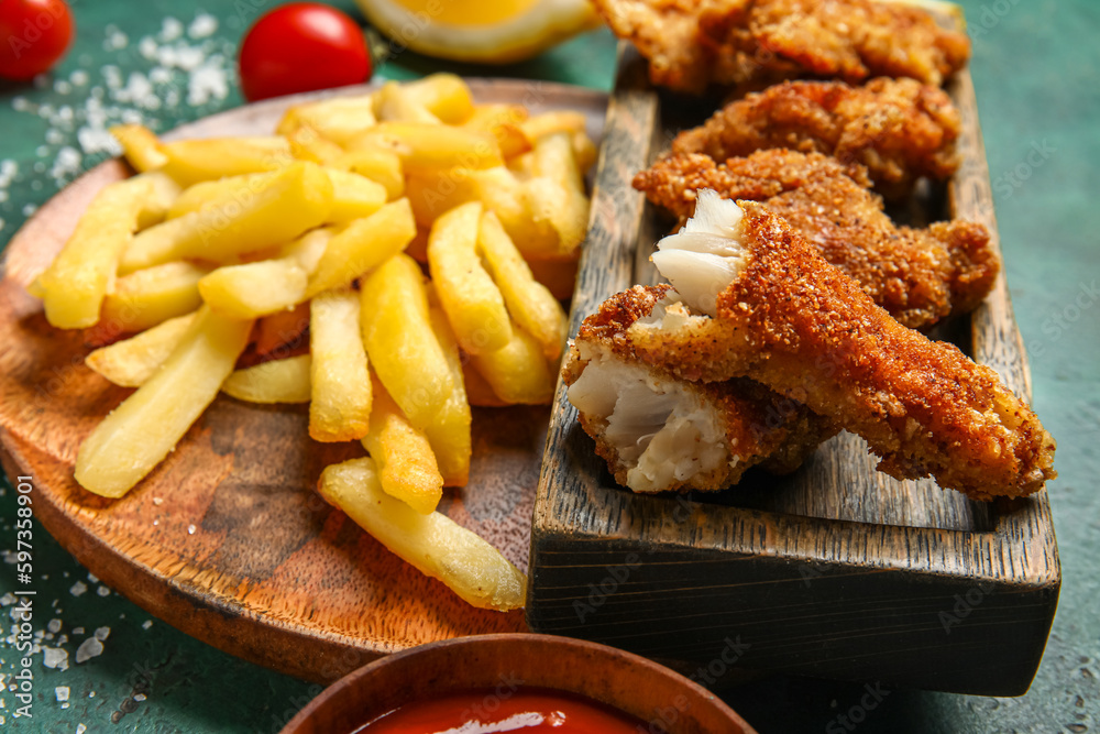 Plate of tasty fried codfish with french fries on green background Plate of tasty fried codfish with french fries on green background