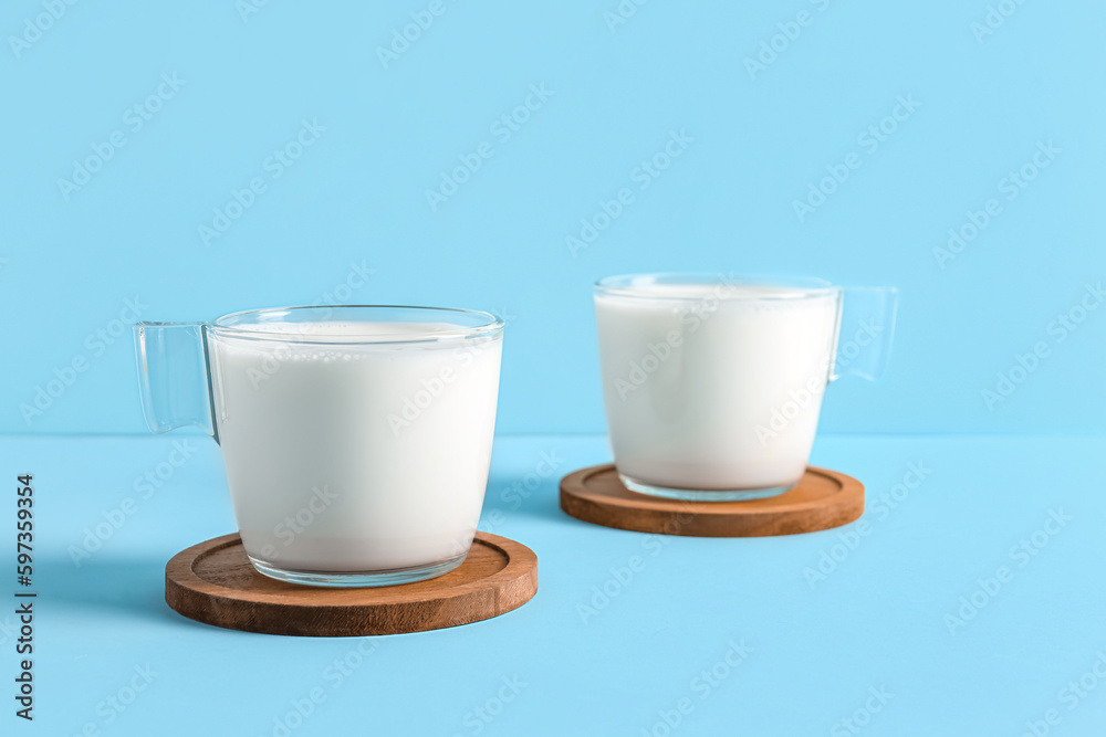 Glass cups with fresh milk on blue background Glass cups with fresh milk on blue background