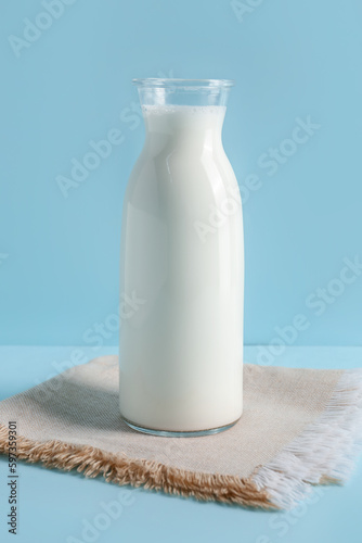Bottle with fresh milk on blue background