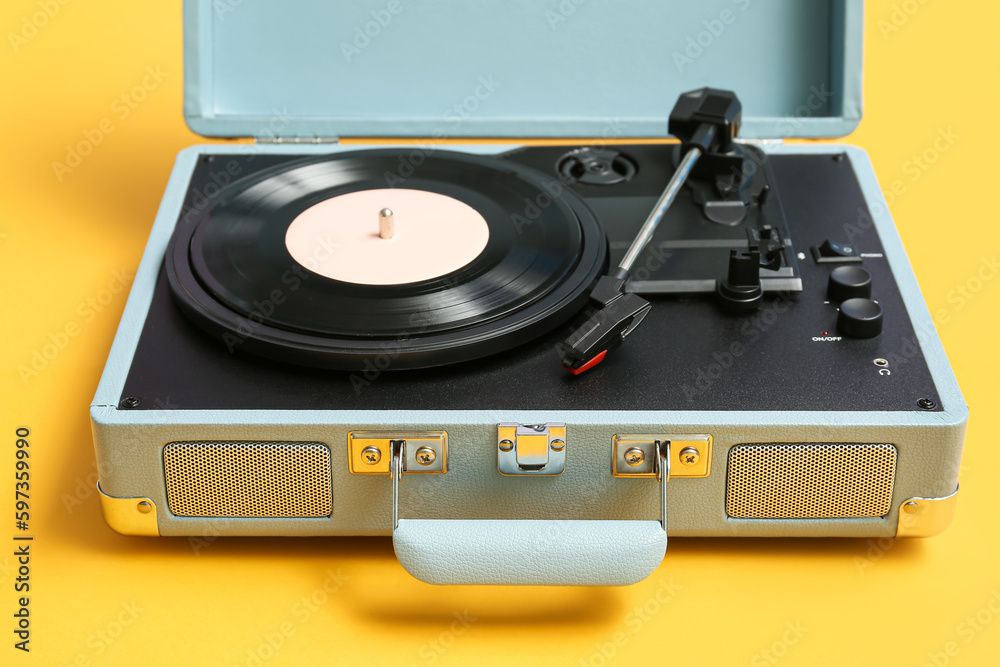 Record player with vinyl disk on yellow background, closeup Record player with vinyl disk on yellow background, closeup