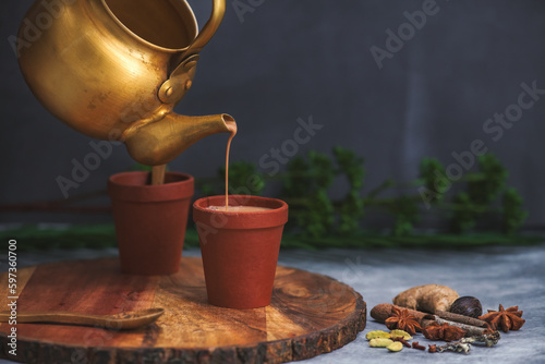 Obraz na płótnie Herbal tea is under process of Pouring in Earthen cups known as Kulhad. Locally called Kulhad chai or cutting chai or masala chai or matka tea. Mud pot tea cups with bio degradable - save environment w salonie
