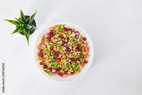 Sprouting green gram bean Indian salad with Onion, coriander leaf , green chilli , Pomegranate and tomatoes. Indian sprouting gram bean salad with isolated background, Healthy eating concept. photo