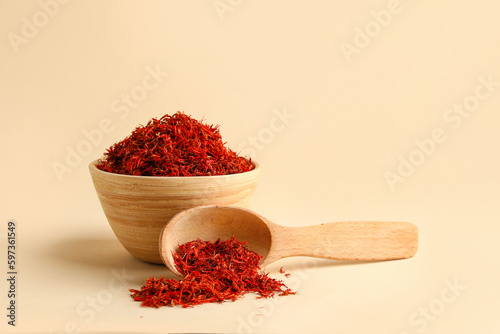 Konstfotografi Wooden bowl and spoon with pile of saffron on light background