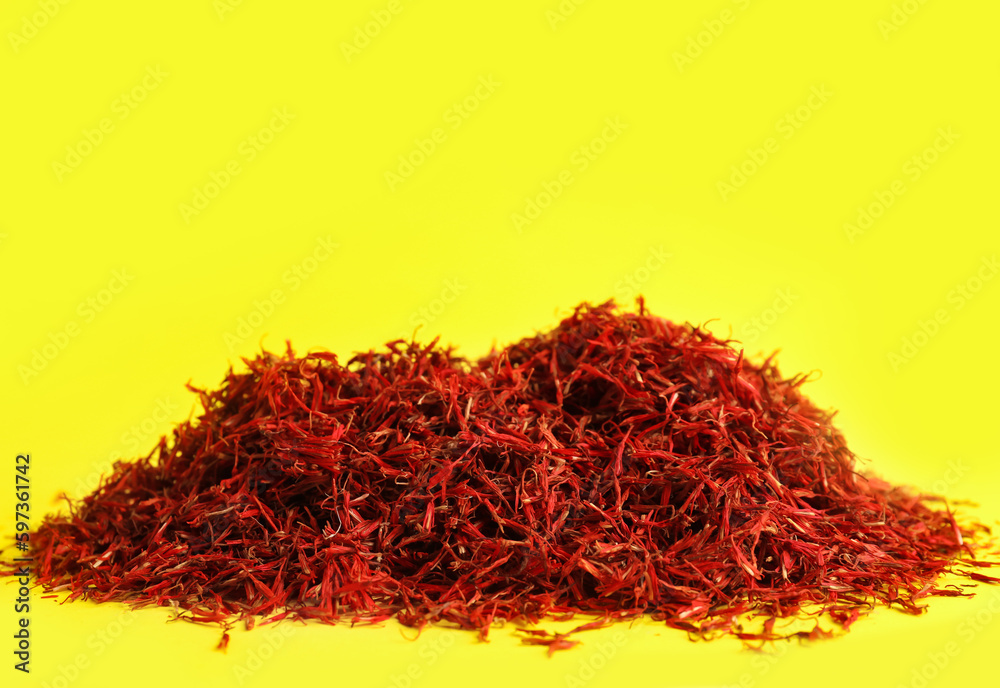 Fototapeta premium Pile of saffron on yellow background