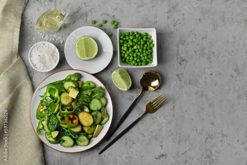 Plate of salad with green vegetables and ingredients on grey grunge background