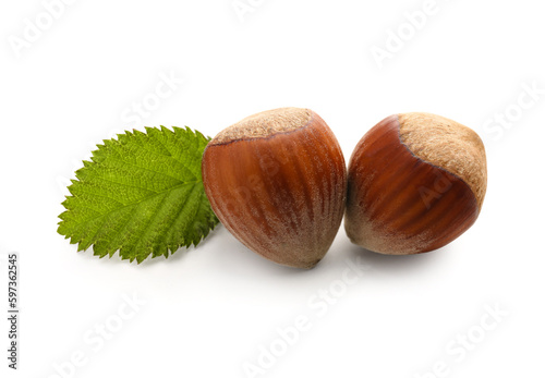 Shelled hazelnuts with leaf on white background