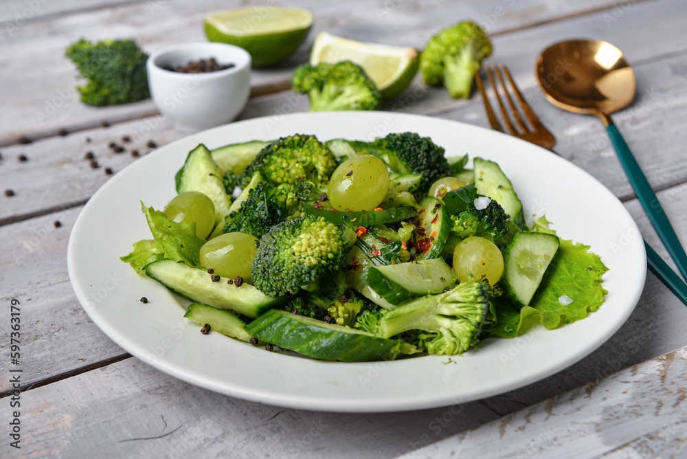 Plate of salad with ingredients on grey wooden background