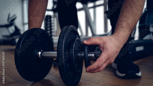 an athlete in the gym is engaged with dumbbells