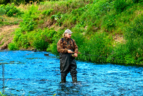 Obraz na plátně A fisherman catches fish while standing in the water