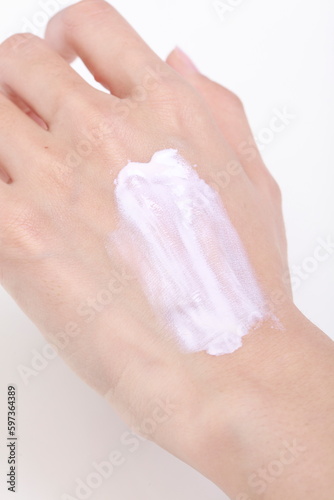 Women's hands. Woman smears cream on her hand on a white background. The concept of cosmetics, skin care, lotion, makeup, spa. Banner Flat lay, closeup