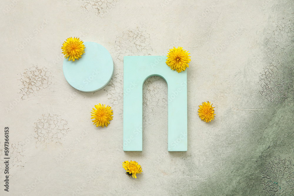 Obraz premium Decorative podiums with dandelion flowers on grey grunge background