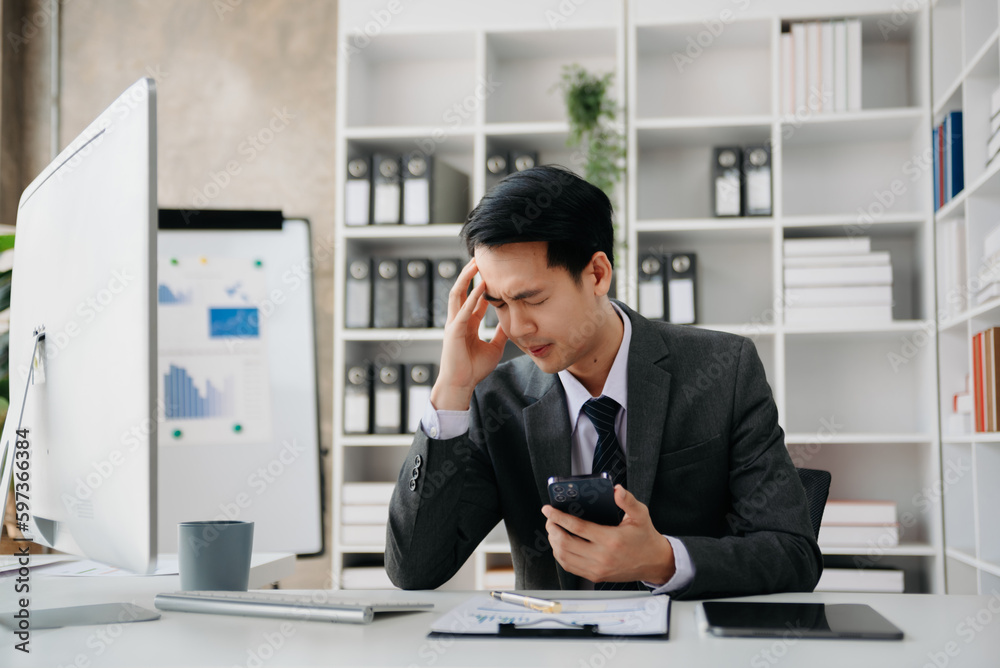 Asian businessman is stressed, bored, and overthinking from working on a tablet at the office. Asian businessman is stressed, bored, and overthinking from working on a tablet at the office.