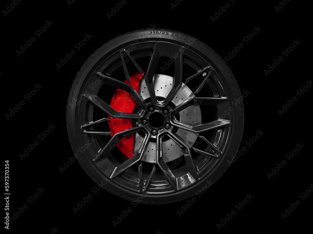 Car alloy wheel and tyre isolated on black background. New alloy wheel with tire and yellow carbon ceramic brakes. Alloy rim isolated. Car wheel disc. Car spare parts.. - obrazy, fototapety, plakaty 