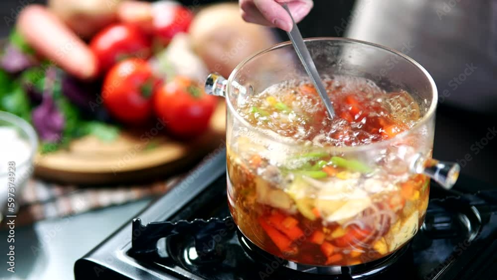 stirring of vegetable soup in pot with ladle stirring of vegetable soup in pot with ladle