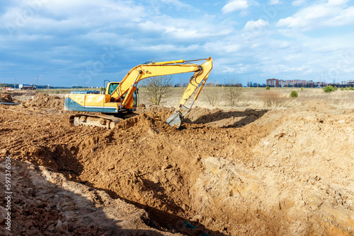 Excavator dig the trenches at a construction site. Trench for laying external sewer pipes. Sewage drainage system for a multi-story building. Digging the pit foundation