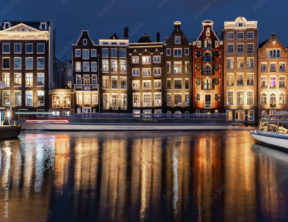 Obraz premium Dancing Houses Damrak Amsterdam during the evening lights Netherlands.