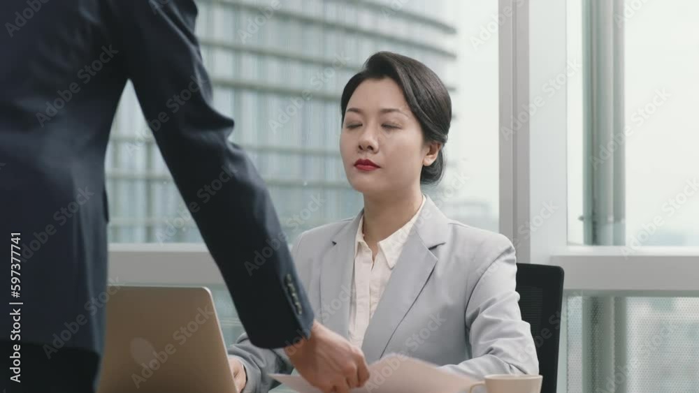 asian manager reviewing and signing in office a document presented by female assistant asian manager reviewing and signing in office a document presented by female assistant
