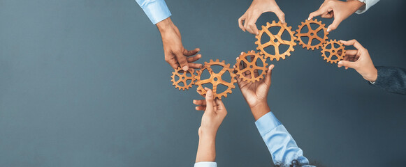 Panoramic shot top view of business people holding cog wheel as unity and teamwork in corporate workplace concept. Office worker colleague with symbol of visionary system for business success. Concord