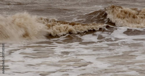 Mid shot of cold bleak looking winter waves breaking on to Ingoldmells, Skegness sandy beach photo