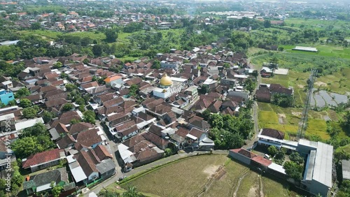 aerial shot of Indonesian village of Panda Pasuran, Beautiful push in movement towards a islamic mosque. an overview shot from Birdseye over the landscape, islamic rural town in Indonesia. photo