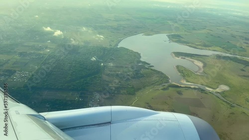 Passenger POV onboard airplane banking over Durazno nature reserve and water reservoir on approach to Buenos Aires Ministro Pistarini International airport. Soft Hazy morning light. photo