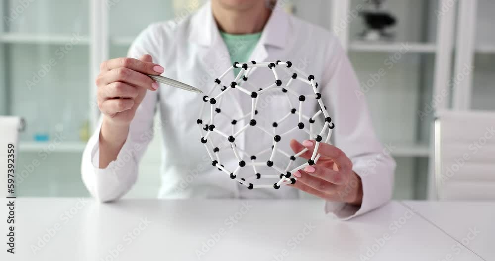 Assistant demonstrates model of molecules of chemical compounds in equipped laboratory. Woman prepares for seminar about special arrangement slow motion